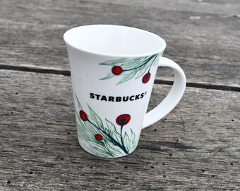 Taza navideña de Starbucks - Diseño de acebo, bayas y ramitas de pino en ambos lados - Capacidad para 295 ml (10 onzas) - Aproximadamente 10,8 cm (4,25 pulgadas) de alto x 8,9 cm (3,5 pulgadas) de diámetro