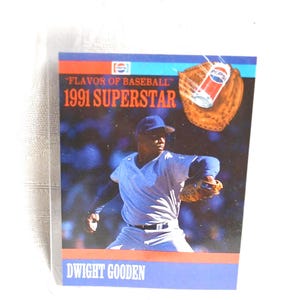 May include: A baseball card featuring Dwight Gooden in a pitching pose. The card has a blue and red border with the text "Flavor of Baseball" and "1991 Superstar." A Pepsi can and baseball glove graphic are also present.