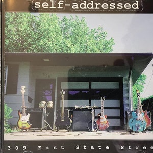 May include: A CD case featuring a photograph of a house with a garage door and several guitars positioned in front of it. The text "self-addressed" is at the top of the image and the text "309 East State Street" is at the bottom of the image.