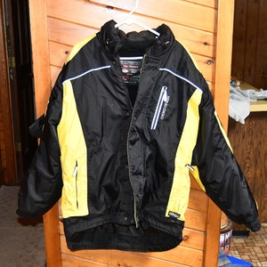 May include: Black and yellow ski jacket with a white zipper and the text "Chrono Design" on the right side.