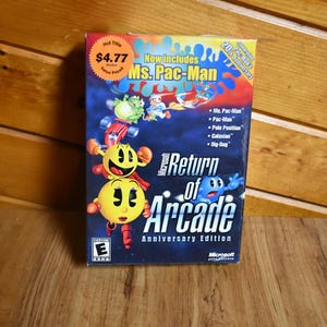 Puede incluir: Una caja de videojuego Microsoft "Return of Arcade" Anniversary Edition. La caja presenta gráficos coloridos de los personajes de Pac-Man y el texto "Ms. Pac-Man" y "20th Anniversary". El juego incluye Ms. Pac-Man, Pac-Man, Pole Position, Galaxian y Dig-Dug.