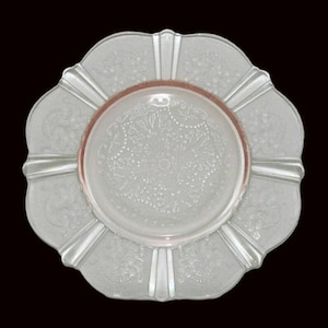 Puede incluir: Un plato de vidrio blanco con un borde festoneado y un borde rosa. El plato tiene un delicado patrón floral y un centro elevado.