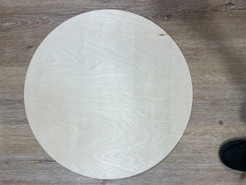 May include: A round, unfinished wooden disc, perfect for crafting projects. The disc is light brown in color and has a smooth surface.