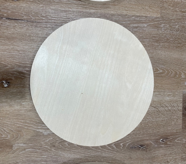 May include: A plain, round, wooden disc with a light beige color and a smooth surface.