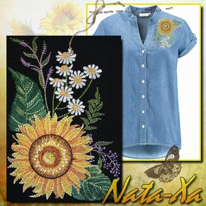 May include: Embroidered denim shirt with a sunflower and daisy design. The shirt has a v-neck and short sleeves. The embroidery is in shades of yellow, white, and green.