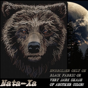 Peut inclure: Broderie représentant le visage d'un ours brun avec des yeux orange. Le texte "Nata-Xa" est en bas de l'image. Le texte "Broder uniquement sur un tissu noir ou une nuance très foncée d'une autre couleur !" est en bas à droite de l'image.