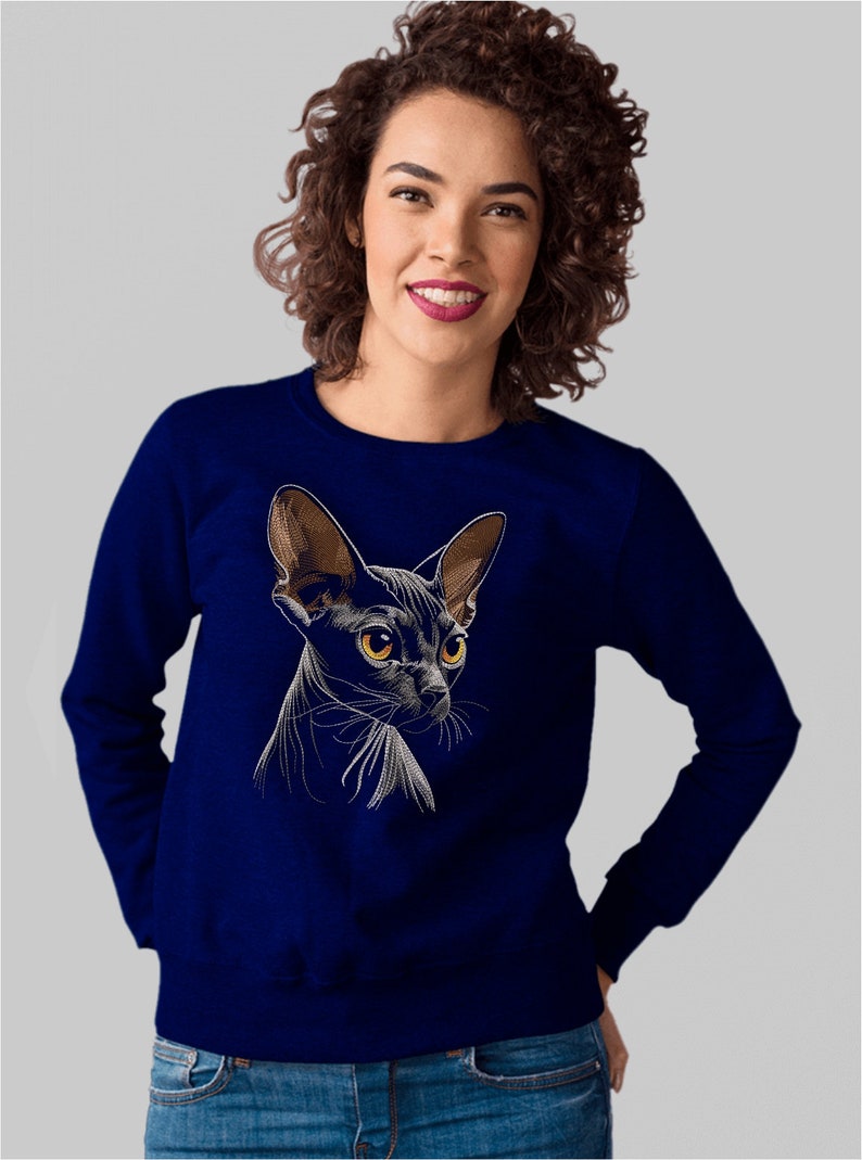 May include: A navy blue sweatshirt with a white embroidered image of a black Sphynx cat.