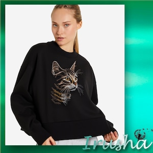 May include: Black sweatshirt with a brown and black cat embroidered on the front. The cat is looking to the right.