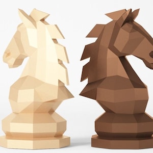 Puede incluir: Dos piezas de ajedrez de origami, un caballo blanco y un caballo marrón, se muestran lado a lado. Los caballos están hechos de papel y tienen un diseño geométrico.