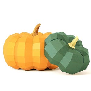Puede incluir: Dos calabazas geométricas de bajo poligonaje, una calabaza grande de color naranja con un tallo marrón y una calabaza más pequeña de color verde oscuro con un tallo amarillo claro. Ambas tienen una superficie facetada de planos triangulares.