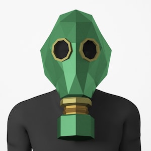 May include: A green and gold gas mask with a geometric design. The mask is made of paper and is a 3D model.