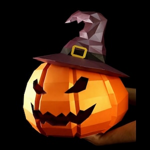 Puede incluir: Una calabaza de papel de bajo polígono con una superficie naranja brillante y una cara de linterna tallada. La calabaza lleva un sombrero de bruja facetado de color púrpura oscuro con una hebilla rectangular amarilla en una banda negra, sobre fondo negro.