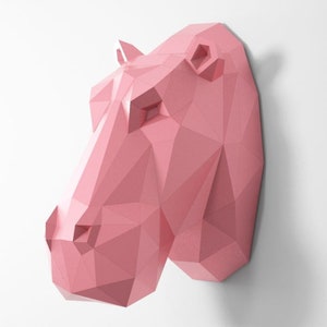 May include: A pink origami-style hippopotamus head wall sculpture. The sculpture is made of paper and has a geometric design.
