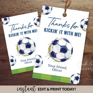 以下が含まれることがあります： サッカーをテーマにした2つの白いギフトタグ。各タグには「Thanks for Kickin' It With Me!」の文字と水彩画のサッカーボールのデザインが施されています。タグには「Your friend, Oliver」の文字も含まれています。1つのタグは長方形で、もう1つは上部が丸くなっています。