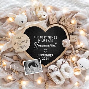 May include: A black heart-shaped chalkboard sign with the text "The best things in life are unexpected" and "September 2024".  The sign is surrounded by wooden blocks that spell out "BABY", a wooden circle with the text "BABY Williams", a small white bunny, and a black and white ultrasound image.