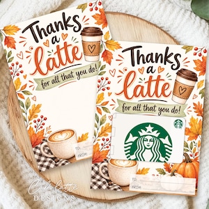 Puede incluir: Dos portatarjetas de regalo rectangulares con ilustraciones otoñales de tazas de café, hojas de arce naranjas y amarillas, y calabazas. El texto dice Thanks a latte for all that you do! con líneas para To y From. Un soporte muestra una tarjeta Starbucks.