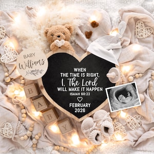 Könnte beinhalten: Eine Babyankündigung mit Teddybär, Babyschuhen und einer herzförmigen Tafel. Auf der Tafel steht "Wenn die Zeit reif ist, werde ich, der Herr, es tun, Jesaja 60:22, Februar 2026". Enthält ein Ultraschallbild und Holzblöcke.