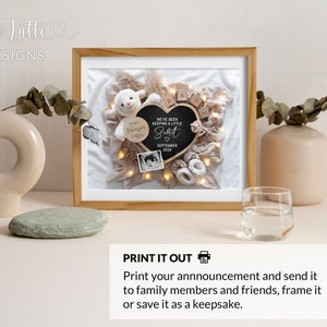 May include: A framed print with a white background and a black heart-shaped chalkboard with the text "We've been keeping a little secret" and the date "September 2024". The print also includes a white stuffed lamb, wooden blocks spelling "baby", and a small white baby bootie.