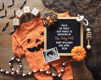 May include: An orange Halloween-themed baby announcement with a pumpkin-faced sweater, a letter board with text, and a sonogram image. Includes a small pumpkin, wooden blocks, and decorative bats.