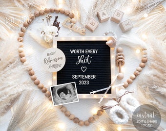 May include: A black letter board with the text "WORTH EVERY Shot" and "SEPTEMBER 2023". A white wooden circle with the text "BABY Robinson" is next to the letter board. A black and white ultrasound image is below the letter board. The background is white with a wooden bead garland and white pampas grass.