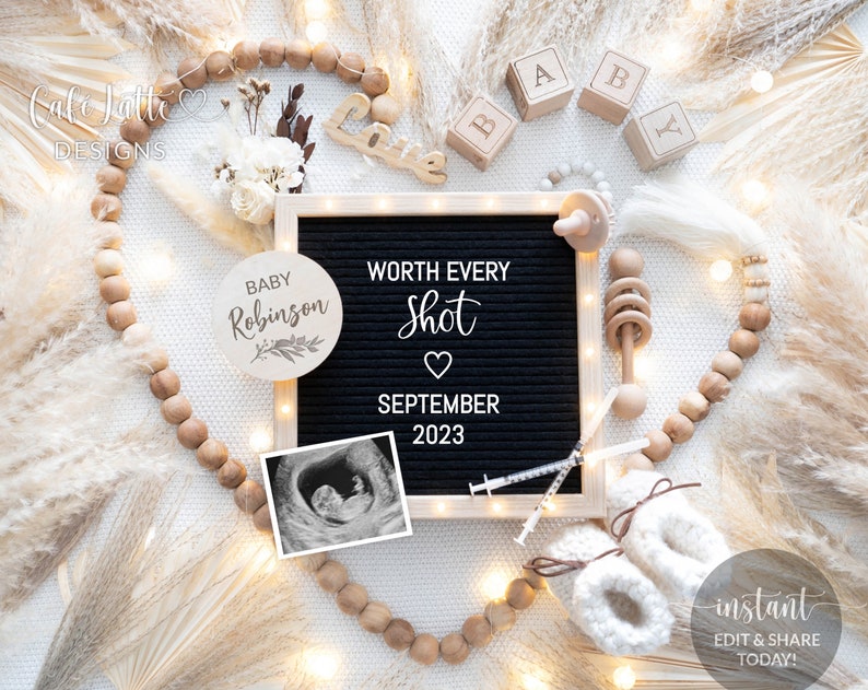 May include: A black letter board with the text "WORTH EVERY Shot" and "SEPTEMBER 2023". A white wooden circle with the text "BABY Robinson" is next to the letter board. A black and white ultrasound image is below the letter board. The background is white with a wooden bead garland and white pampas grass.
