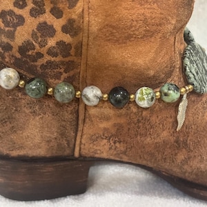 Boot bracelet with green tone disks and feather charms