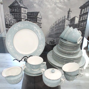 May include: A set of blue and white china dinnerware with a floral pattern. The set includes plates, cups, saucers, a creamer, and a sugar bowl.