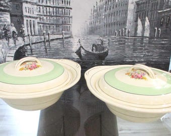 May include: Two vintage white ceramic serving bowls with green and gold trim and floral designs. The bowls have lids.