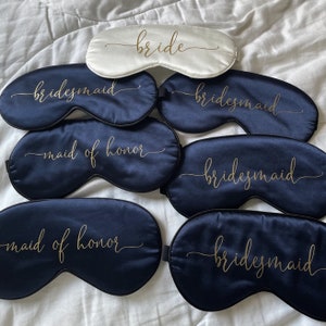 Puede incluir: Conjunto de seis antifaces de sat&eacute;n con letras doradas. Una m&aacute;scara dice "bride" y las dem&aacute;s dicen "bridesmaid" o "maid of honor".