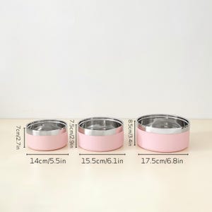 May include: Three stainless steel and pink food storage containers. The smallest is 5.5 inches wide and 2.7 inches tall. The medium container is 6.1 inches wide and 2.9 inches tall. The largest is 6.8 inches wide and 3.4 inches tall.