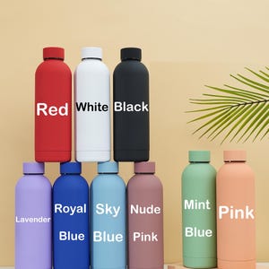 May include: Nine different colored reusable water bottles with labels indicating their color. The colors are red, white, black, lavender, royal blue, sky blue, nude pink, mint green, and pink.