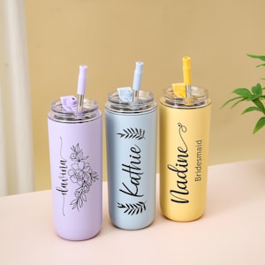 May include: Three personalized stainless steel tumblers with straws. One is lavender with a floral design and the name "Davina". The second is light blue with the name "Kathie". The third is yellow with the name "Nadine" and the word "Bridesmaid".