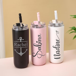 May include: Three personalized stainless steel tumblers with straws. One is black with an anchor design and the name "Rachel". The second is pink with the name "Sabina". The third is white with the name "Nadine". Each tumbler has a clear lid.