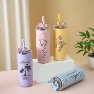 May include: Four personalized stainless steel tumblers in pastel colors. One lavender tumbler has a palm tree design and the name "Amelia" and the year "2026". A pink tumbler has a stethoscope design and the name "Austin". A yellow tumbler has a floral design and the name "Davina". A blue tumbler has the name "Madine" and the word "Bridesmaid".