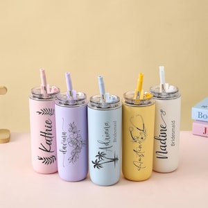 May include: Five personalized stainless steel tumblers with straws in pastel colors: pink, lavender, light blue, yellow, and white. Each tumbler features a name and a decorative design, such as leaves, flowers, or a stethoscope.