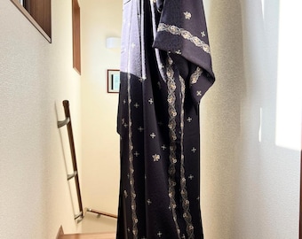 May include: A black kimono with a gold and white floral pattern. The kimono is made of a soft, silky fabric and has a traditional Japanese design.
