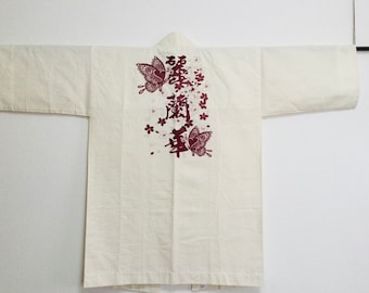 May include: A white cotton yukata with a red and white butterfly design and Japanese characters. The characters read "Sakura" and "Year".