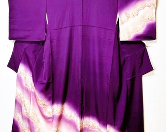 May include: A vibrant purple kimono with a flowing design. The garment features a gradient pattern of light pink and gold waves along the bottom and sleeves. The kimono is made of a smooth, likely silk, fabric.