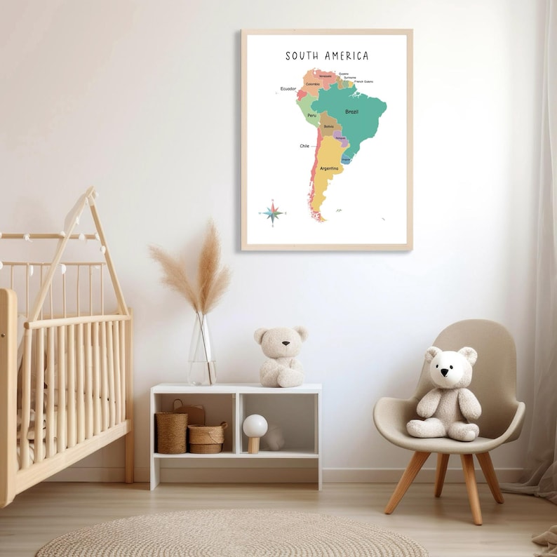 May include: A framed map of South America with the countries labeled in different colors. The map is hanging on a white wall in a nursery with a crib, a shelf, and a chair with a teddy bear sitting on it.