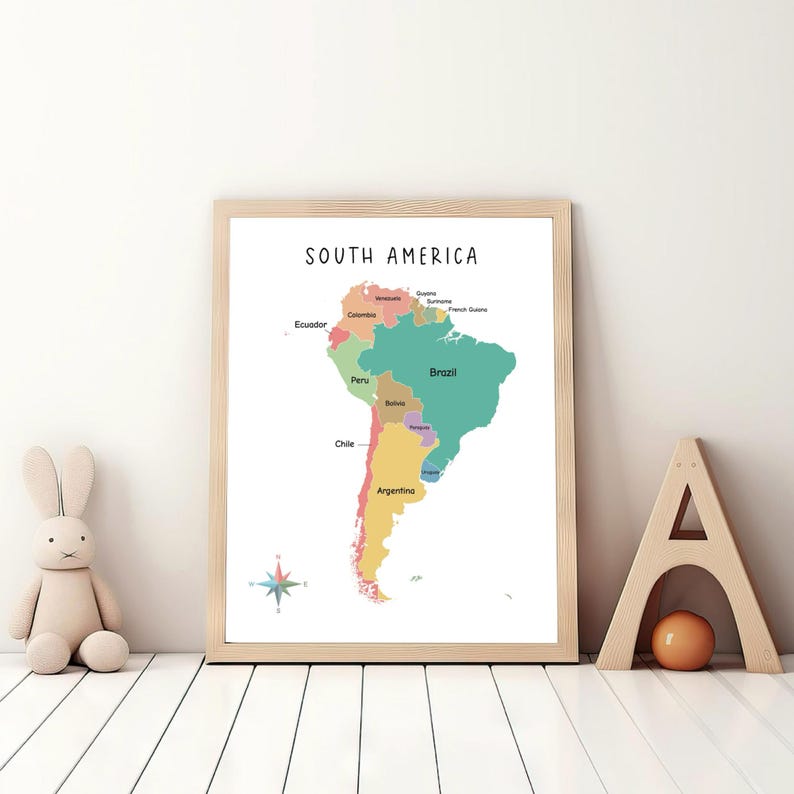 May include: A colorful map of South America with the countries labeled in black text. The map is framed in a light wood frame and is hanging on a white wall.