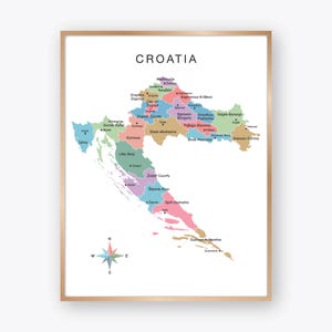 May include: A framed wall art print featuring a colourful map of Croatia. The map displays various counties in pastel shades of blue, green, pink, and tan, with black text labels for regions and cities. The word CROATIA is printed at the top.