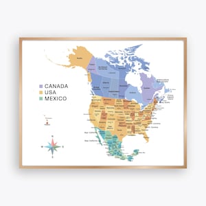 May include: A framed wall map of North America featuring Canada in purple, the USA in tan, and Mexico in teal. The map includes state and provincial labels, a compass rose in the bottom left corner, and a legend listing the three countries.