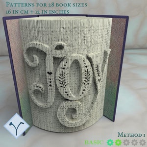 Peut inclure: Un livre dont les pages sont découpées pour former le mot "JOY". Le livre a une tranche violette et le texte "PATTERNS FOR 28 BOOK SIZES 16 IN CM + 12 IN INCHES" en haut. Les mots "BASIC" et "METHOD I" sont également visibles.