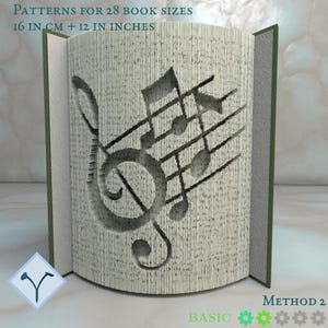 Può includere: Scultura di libro con un disegno di note musicali intagliato nelle pagine. Il testo sul libro recita "PATTERNS FOR 28 BOOK SIZES 16 IN CM + 12 IN INCHES" e "METHOD 2 BASIC". Il libro è aperto, rivelando il design.
