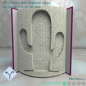 May include: A folded book art sculpture forming a cactus shape with purple covers. Text reads: PATTERNS FOR 28 BOOK SIZES 16 IN CM + 12 IN INCHES, METHOD 2, BEGINNER. The pages are folded to create a three-dimensional silhouette of a saguaro cactus.