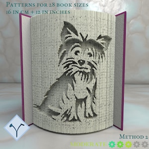 Könnte beinhalten: Eine Schwarzweißillustration eines sitzenden Yorkshire Terriers mit geneigtem Kopf. Das Bild ist ein Muster für ein Buchfaltenprojekt mit Anleitungen für 28 verschiedene Buchgrößen in Zentimetern und Zoll.