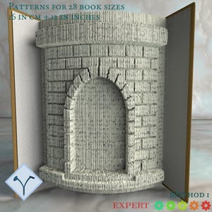 Op de afbeelding: Een boeksculptuur met een baksteenboogontwerp. De tekst "PATTERNS FOR 28 BOOK SIZES" en "16 cm + 12 inch" zijn zichtbaar. Het boek is open en toont het gesneden ontwerp. Het woord "EXPERT" is ook zichtbaar.