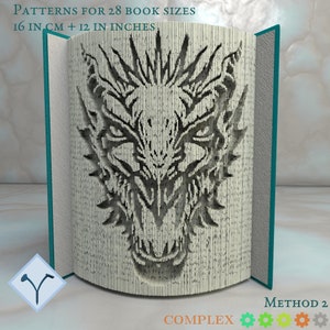 May include: A book with a dragon head design created by folding the pages. The book is teal blue and the dragon is black and white. The text on the book reads "Patterns for 28 book sizes 16 in cm + 12 in inches" and "Method 2 Complex".