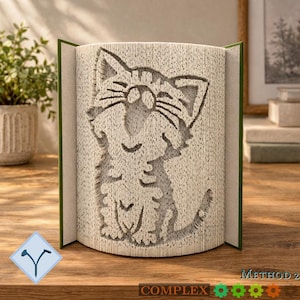 Könnte beinhalten: Eine Buchfaltkunst-Skulptur mit einem Katzendesign, das durch präzises Falten der Buchseiten entsteht. Die Katzenfigur wird durch die Papierkanten gebildet und zeigt ein sitzendes Tier mit spitzen Ohren und einem geschwungenen Schwanz.