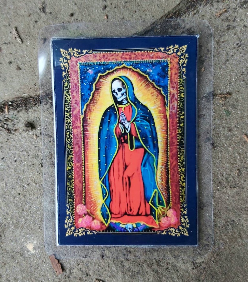May include: A colorful image of a skeleton dressed as the Virgin Mary. The image is framed in gold and set against a blue background.